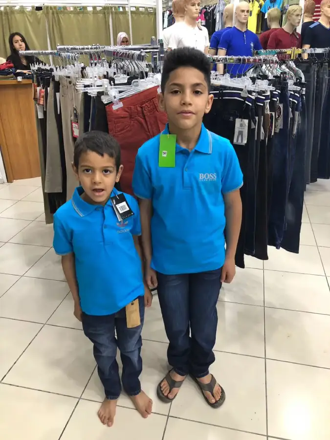 Deux enfants dans un magasin de vêtements, lors d’une action présentée par l’association